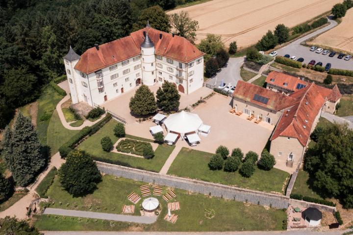 Luftaufnahme von Schloss Neuhaus bei Sinsheim, mit beeindruckendem Garten und umliegender Landschaft.